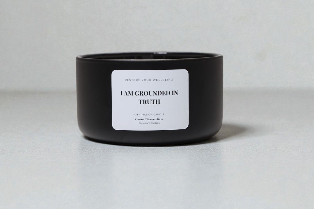 Black 8 oz Calista glass candle labeled “I Am Grounded in Truth” against a neutral background
